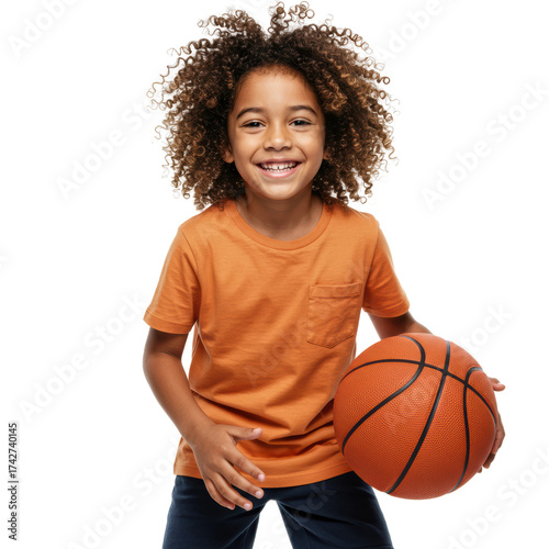 Happy young boy with curly hair holding a basketball and smiling.