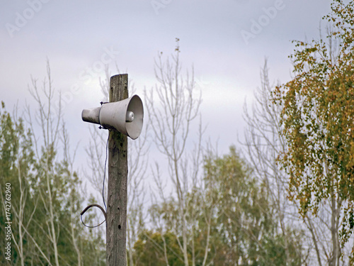 An Old Loudspeaker or Air Raid Siren on a Wooden Pole - An emergency warning siren