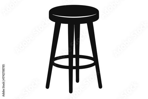 The black three legged stool stands alone prominently against the white background space