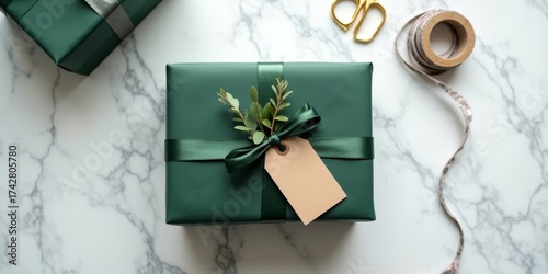 Minimalist deep green gift box with satin ribbon and eucalyptus on marble countertop, Scandinavian Christmas wrapping
