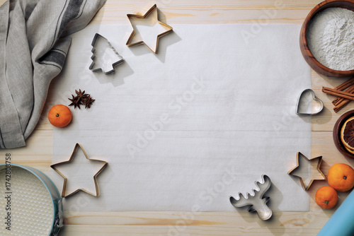 Top-down frame of holiday ingredients and tools surrounding a flour-dusted space for dough preparation.