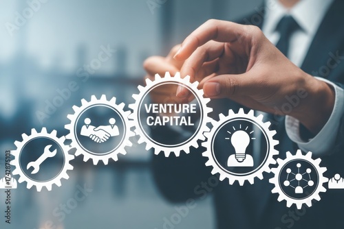 A hand is setting gears together, highlighting venture capital and business concepts. The gears have various icons, representing teamwork, tools, and ideas