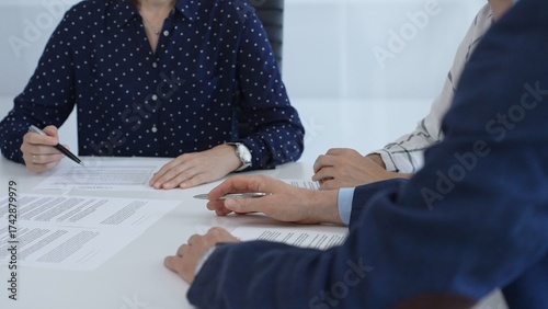Tableau sur toile Business people reviewing contract during a meeting, pointing at specific clause