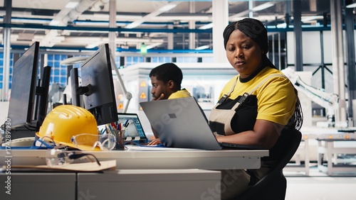 Black woman technician testing solar panel designs on industrial software, working in alternative energy manufacturing plant. Female engineer optimizing the production line. Camera B.