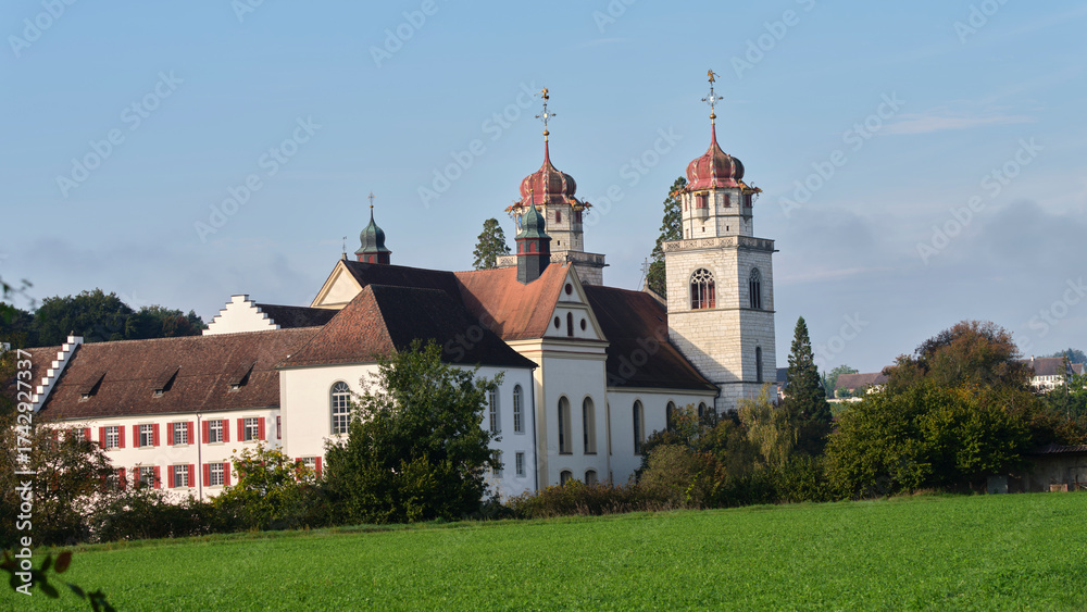 Naklejka premium Historic church and buildings surrounded by nature on a clear day in Switzerland