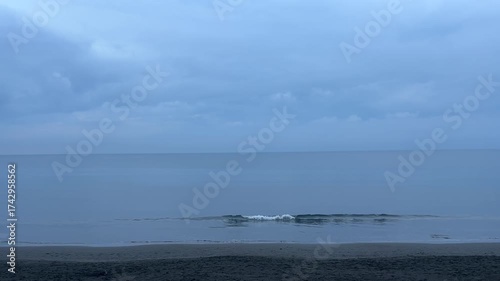 波打ち際で穏やかに白い波が割れる夏の終わりの夕方の静かなビーチ
