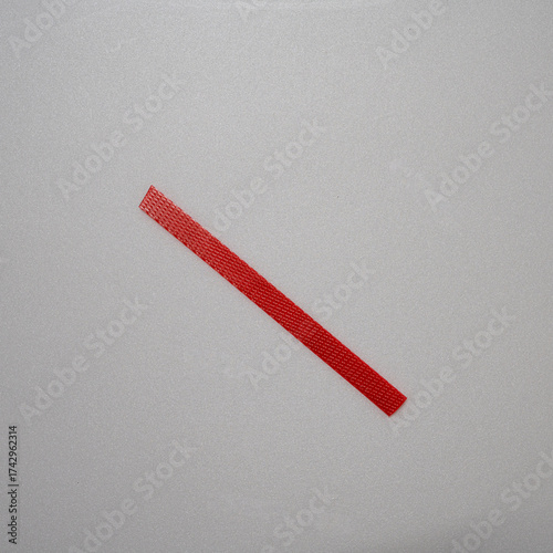 Close-up of a yellow plastic strap tied in a simple knot against a light surface. The image highlights its smooth texture, flexibility, and industrial design.