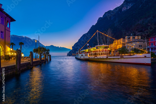 View of beautiful Lake Garda surrounded by mountains, Panoramic autumn view of sunset over Lake Garda in the evening with beautiful sunset colors, Italy