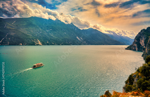 View of beautiful Lake Garda surrounded by mountains, Panoramic autumn view of sunset over Lake Garda in the evening with beautiful sunset colors, Italy