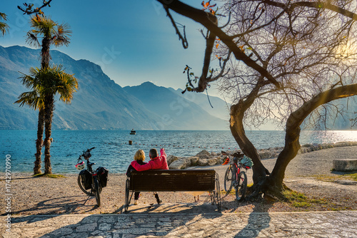 View of beautiful Lake Garda surrounded by mountains, Panoramic autumn view of sunset over Lake Garda in the evening with beautiful sunset colors, Italy