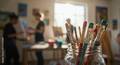 Close-up of paintbrushes in a glass jar inside an art studio