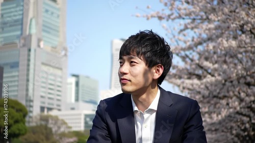 Wallpaper Mural Young Businessman Contemplating Amidst Cherry Blossoms and Cityscape Torontodigital.ca