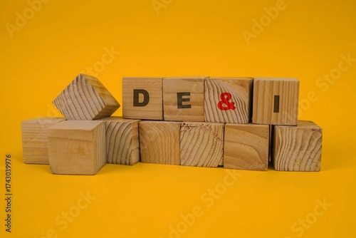 Words DEI, Diversity, Equity And Inclusion On Wooden Cubes On Yellow Background