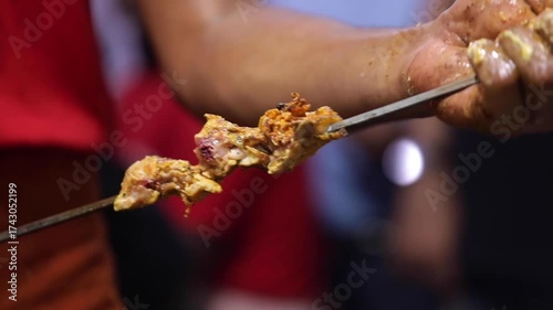 Marinated chicken wings on a skewer.