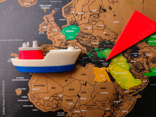 The image shows a map of Europe and the Middle East, with a toy ship and a red arrow placed on it