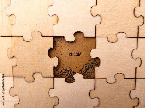 The image shows a wooden jigsaw puzzle with a section of a map of Russia visible