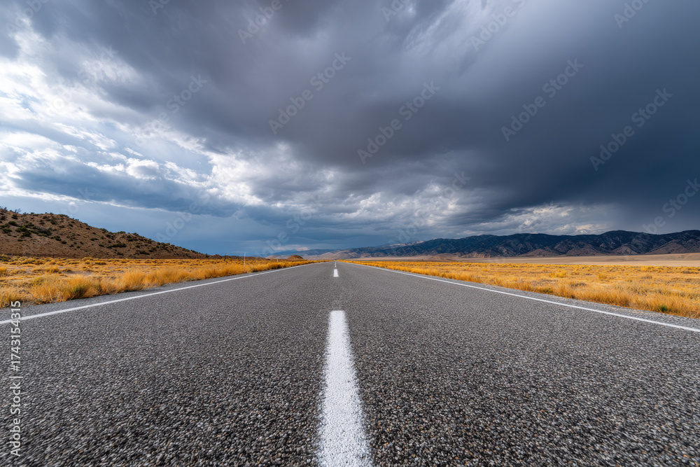 Fototapeta premium Empty highway stretching into the horizon under dramatic clouds