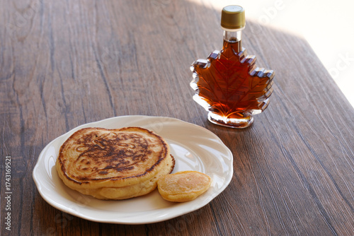 白い皿に乗ったパンケーキとメープルシロップ