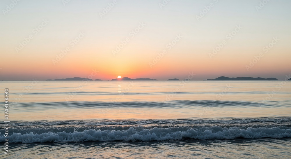 Fototapeta premium Tranquil seascape at dawn with rising sun over calm ocean waves and distant islands