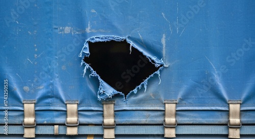 Close-up of blue truck trailer awning, visibly cut, cut wallpaper damaged, revealing cargo theft concerns. Represents breakdown in security for transported goods, risks in freight delivery, 