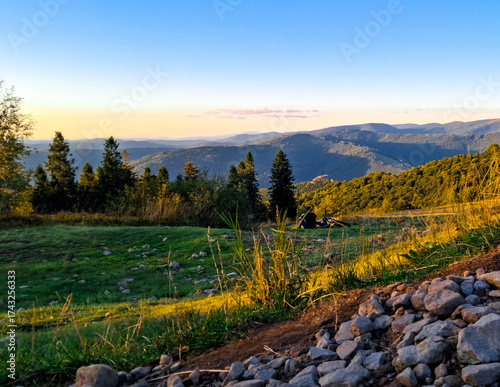 Fototapeta Naklejka Na Ścianę i Meble -  Biker relaxing on a meadow in Beskids.
