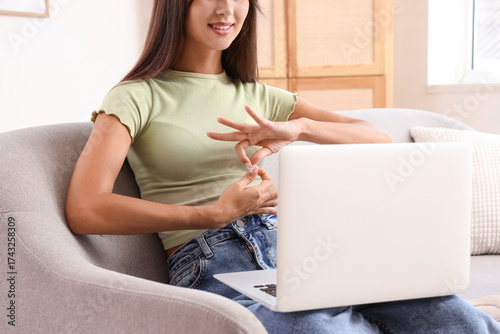 Young woman with laptop usi...