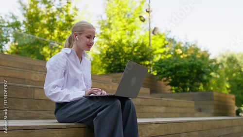 Student studying online with laptop outdoors