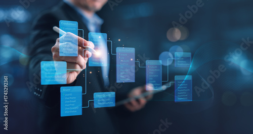 Professional designing relational database structure tables and fields on digital interface, showing data connection, system architecture, and information management for modern business solutions.