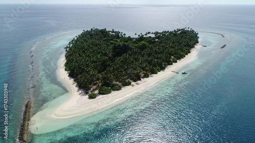 Aerial view of a heartshaped island paradise with Maldives, and surrounded by turquoise ocean.