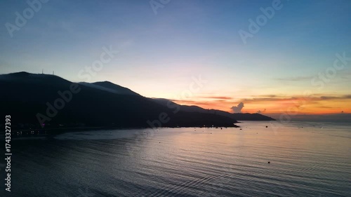 Warm sunlight illuminating son tra mountain's coastal landscape, golden rays casting ethereal glow across serene da nang bay during spectacular dawn moment
