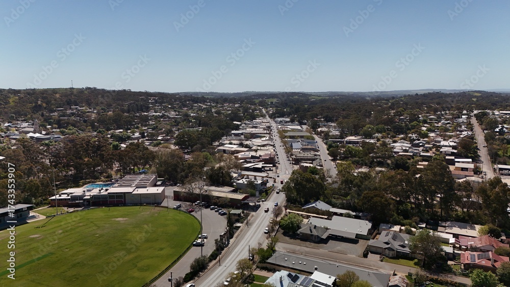 Fototapeta premium Clare, South Australia – Aerial Drone Image of Clare Valley Township Featuring Main Street, Green Parks, Sports Oval, Houses, Estates, and Rolling Hills in the Renowned Wine Region