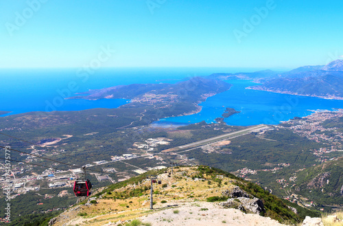 A cable car in Montenegro. Aerial view of picturesque cableway and Bay of Kotor. Top view on Tivat, mountains and Adriatic Sea, Montenegro. Bird's-eye view of Gulf of Kotor, view from Mount Lovcen