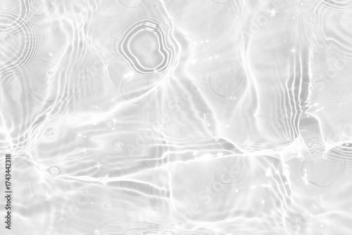 White water with ripples on the surface. Defocus blurred transparent white colored clear calm water surface texture with splashes and bubbles. Water waves with shining pattern texture background.