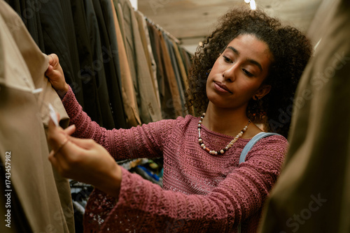 Person choosing clothes in fashion store while shopping