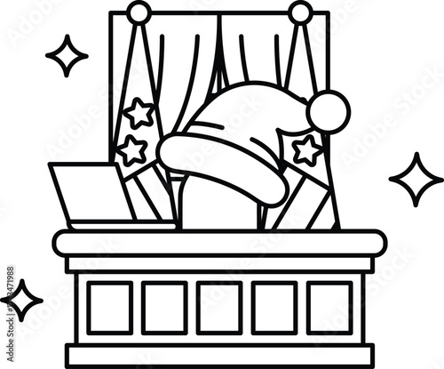 A man in a Santa hat sits at a desk with a laptop