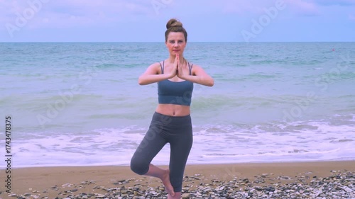 A woman meditates standing on the beach in the morning slow motion. Meditation in nature. Healthy lifestyle. Yoga, Relaxation, Zen, Concentration, Meditating.