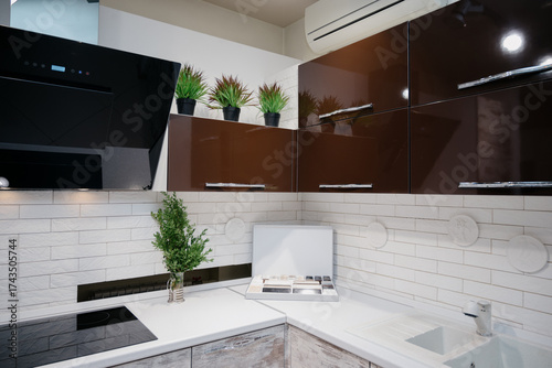 A trendy kitchen with white countertops, an induction hob, and spotlights