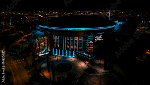 Aerial view of the luminous Ball Arena stands brightly against the dark sky, a beacon in the night, Denver, Colorado, United States.