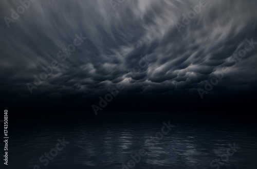 Dark stormy sky over calm ocean surface.