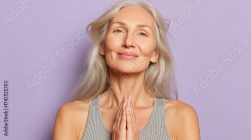 Smiling woman with long gray hair, purple background.