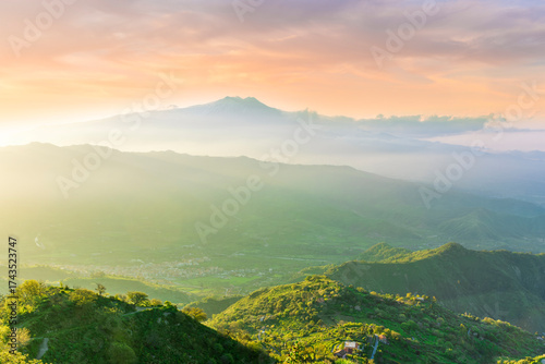 highland mountain landscape of beautiful sunset or sunrise with nice mountain peaks and slopes, green and golden hills and majestic cloudy sky on background