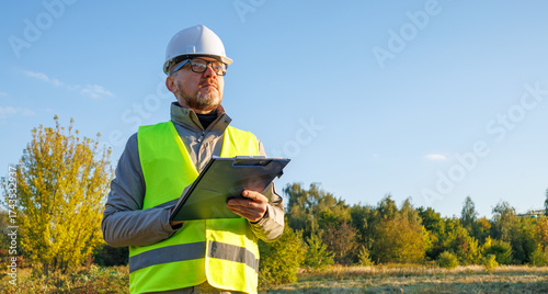 Male engineer inspects the condition of a new construction site. Work forestry inspector, environmental control. Ecologist conducts environmental monitoring soil analysis. 