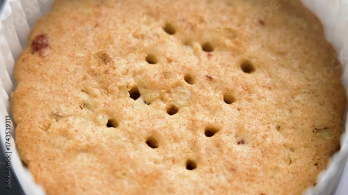 Round cookies with a hole pattern and red cranberry pieces in paper packaging