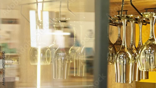 A man takes a wine glass from a display cabinet and closes the door.