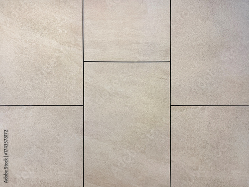 Close up of grey stone tiles with black grouts. Natural light grey stone slate tiles with rough surface. Seamless background texture.