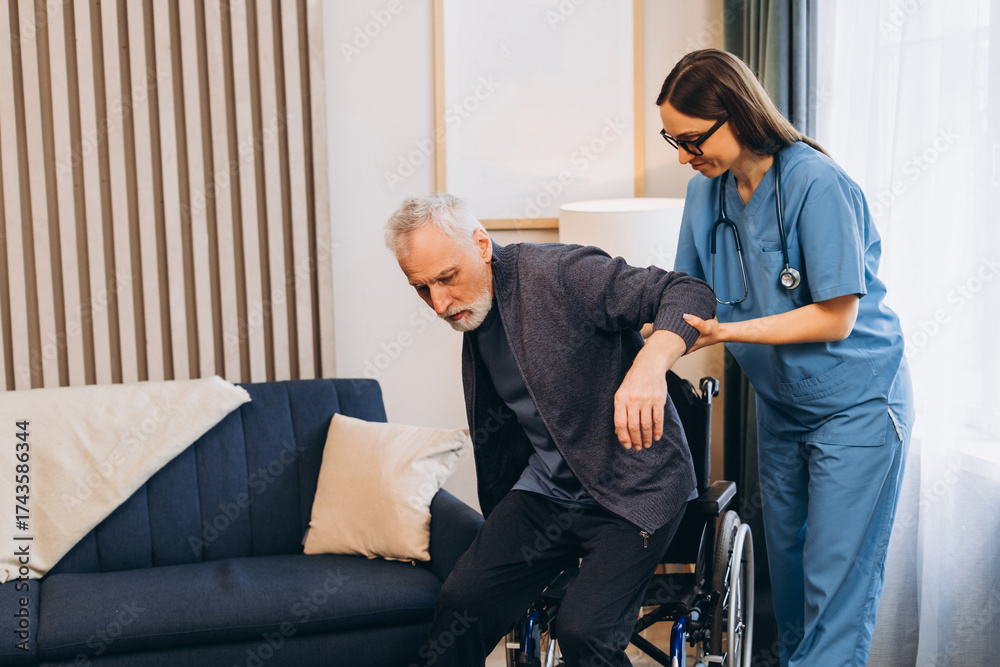 Obraz premium Caregiver beautiful woman helping elderly man getting out wheelchair, training