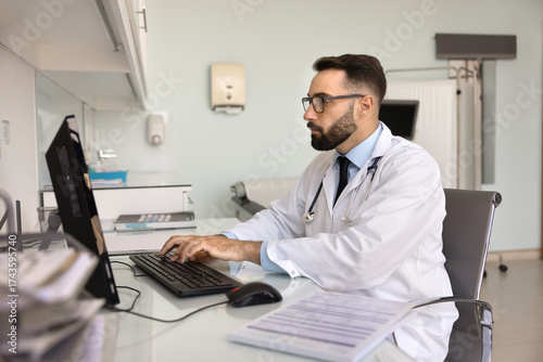 Photography Serious doctor working at desk in modern medical office