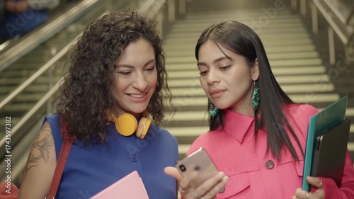 Women connect over a phone during their Quito metro commute