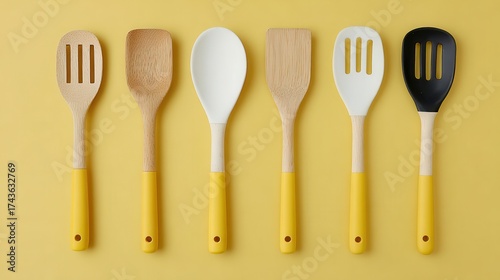 Modern kitchen utensils set featuring wooden silicone and black spatulas with yellow handles ideal for food preparation cooking and culinary presentation