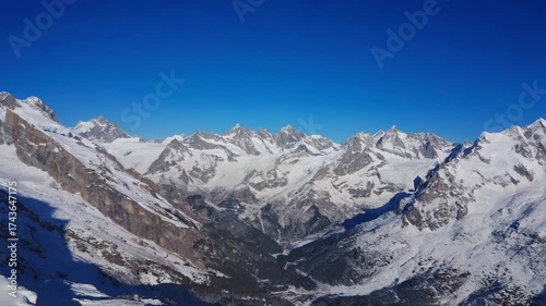 Experience the breathtaking beauty of snow-capped mountains against a clear blue sky, perfect for adventure travel, winter sports, or stunning landscape visuals in your next project